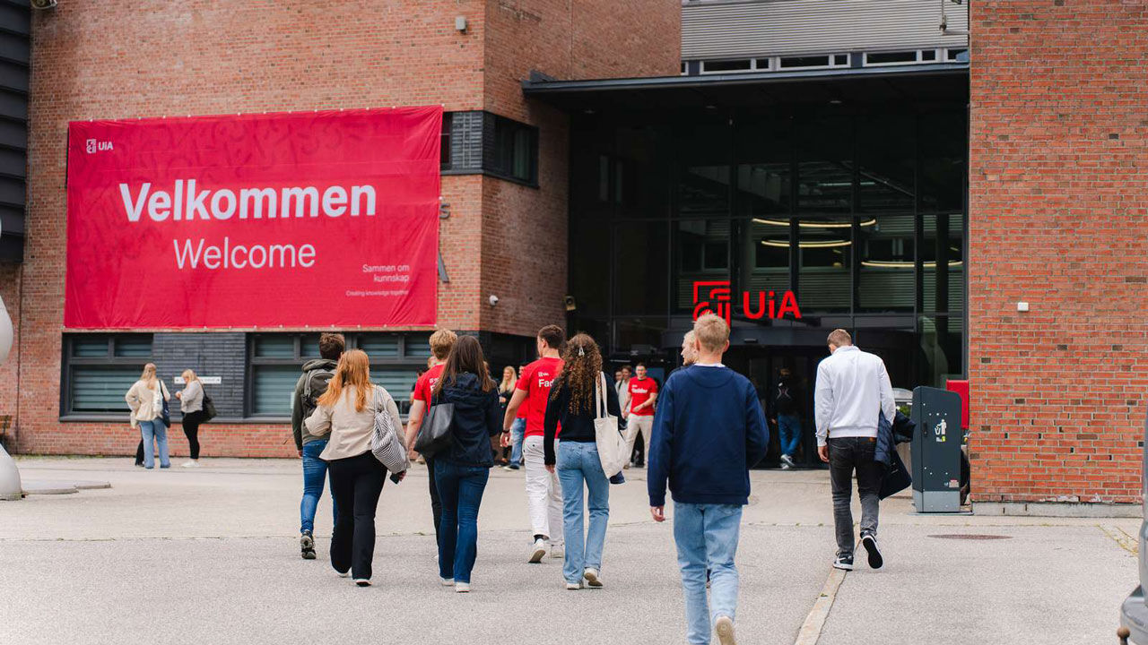 Bilde av studenter på vei inn hovedinngangen på Campus Kristiansand ved en tidligere studiestart