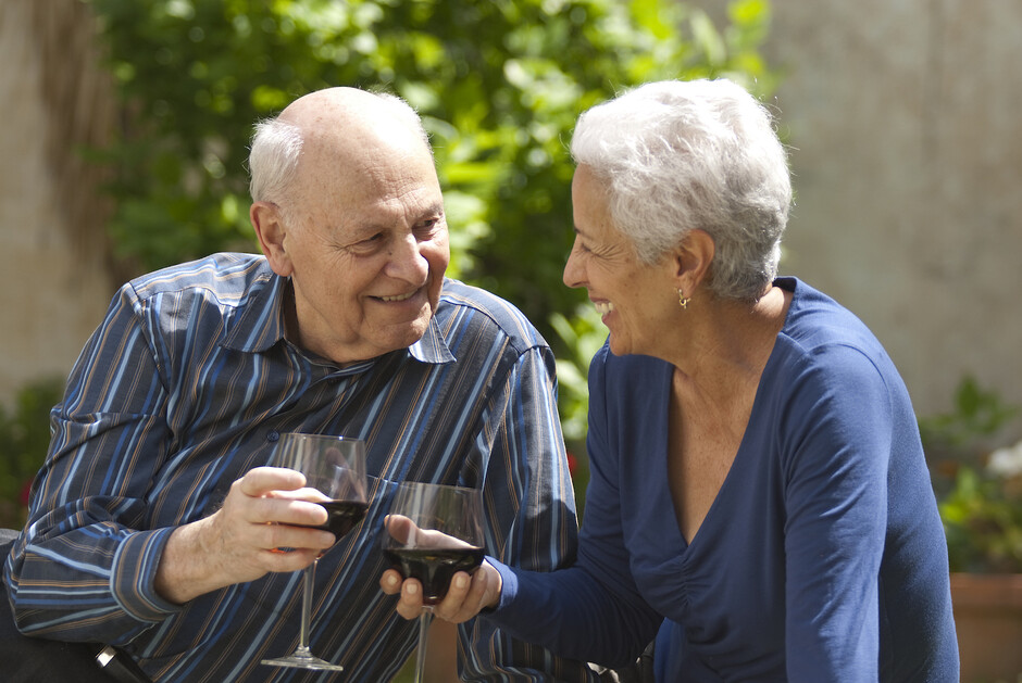 Photo shows old couple drinking vine. 