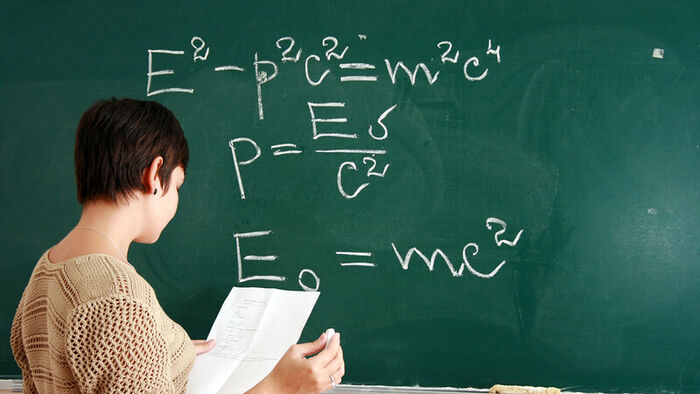 Illustrasjonsfoto av person som skriver matematiske formler på en tavle