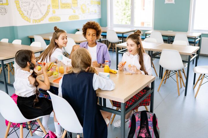 Elever på barneskolen spiser sammen. 