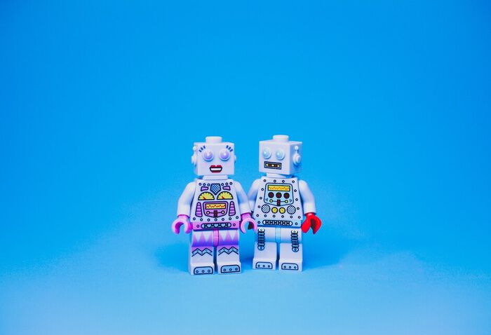 Bildet viser to roboter som holder hender.