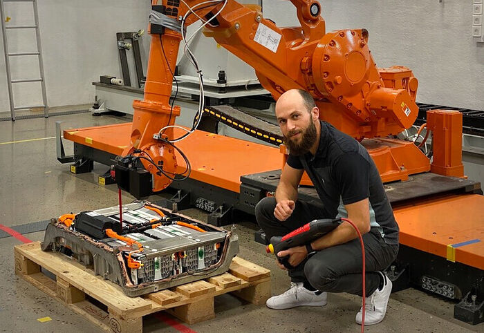 Bildet viser forskeren Martin Choux som viser hvordan kunstig intelligens styrer en robot-arm.