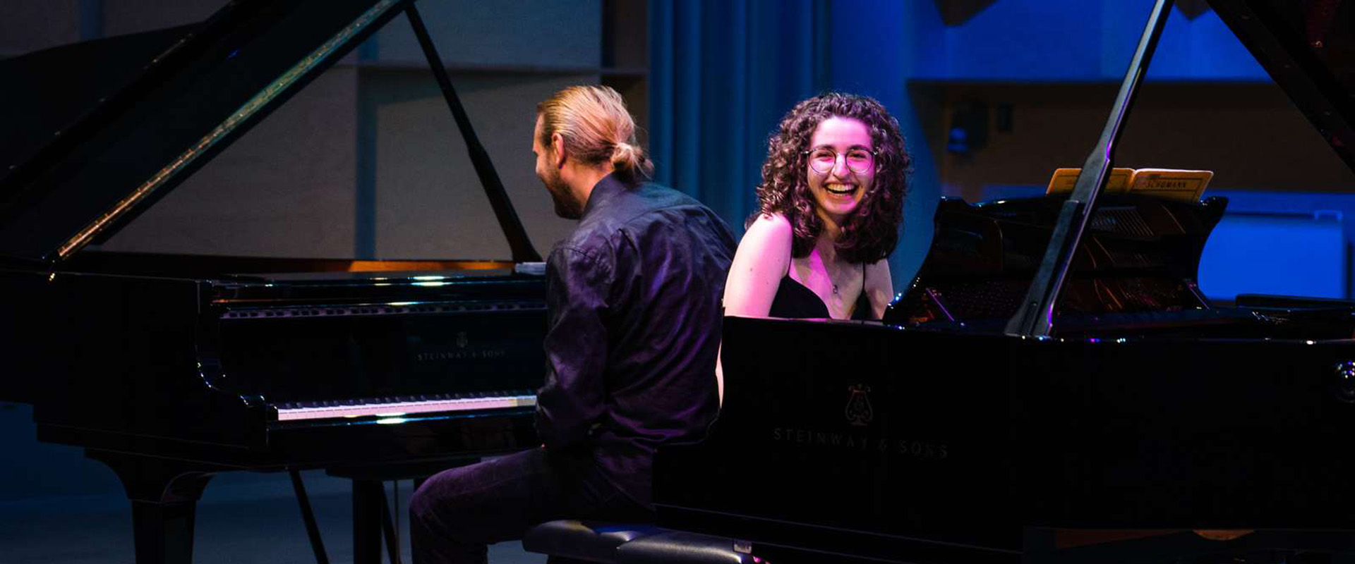 Two pianists, two grand pianoes, classical concert, smile