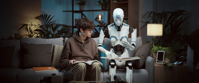 Gutt og robot sitter sammen og leser.