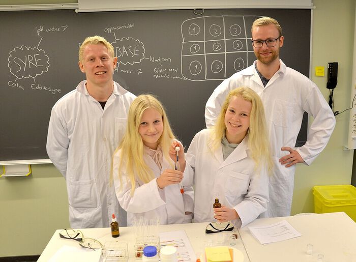Fire studenter i hvite frakker