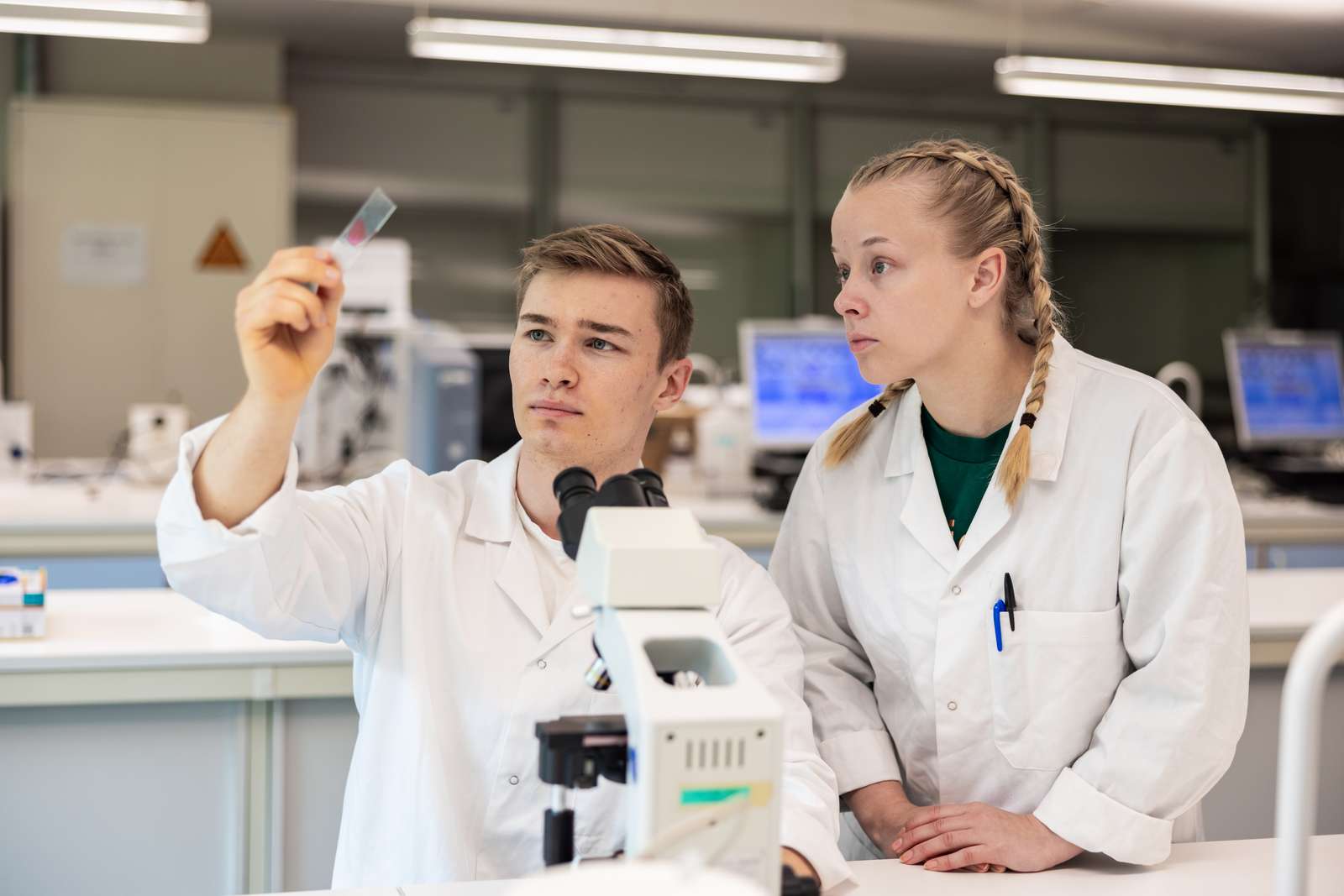 To studenter i hvit frakk i et laboratorium