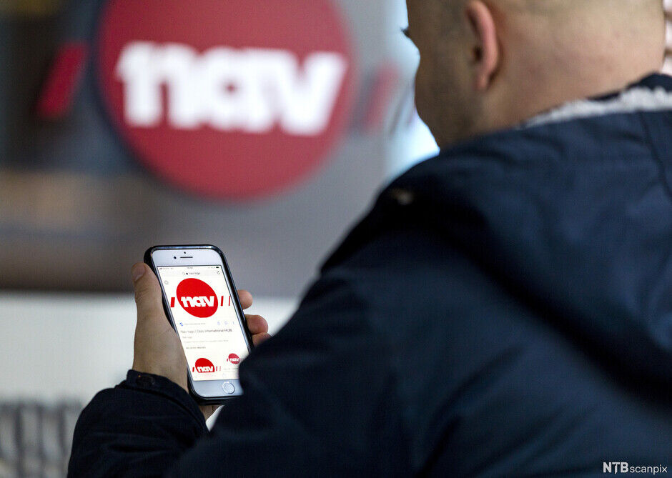 A man looks at the NAV website, with the NAV logo visible in the background