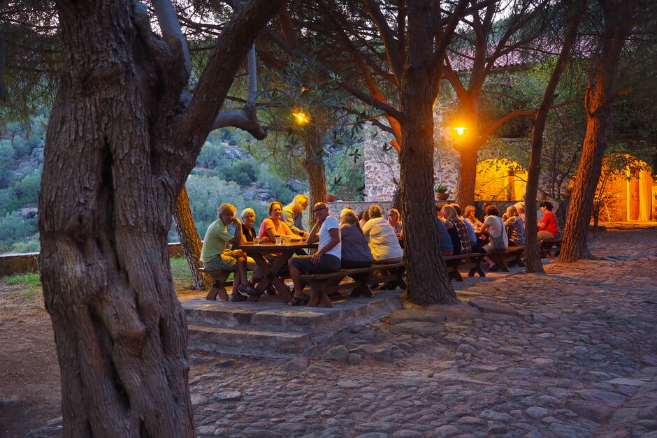 Samling på Metochi, en gruppe mennesker er samlet rundt et spisebord ute om kvelden.
