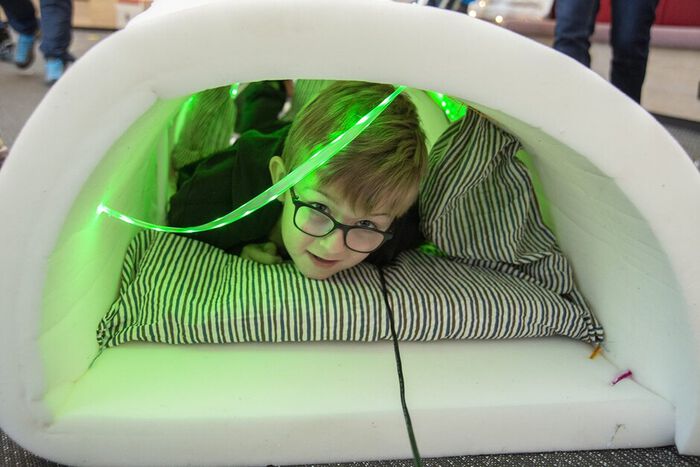 Barn som prøver ut en av maskinene som er laget av en madrass med led-lys.