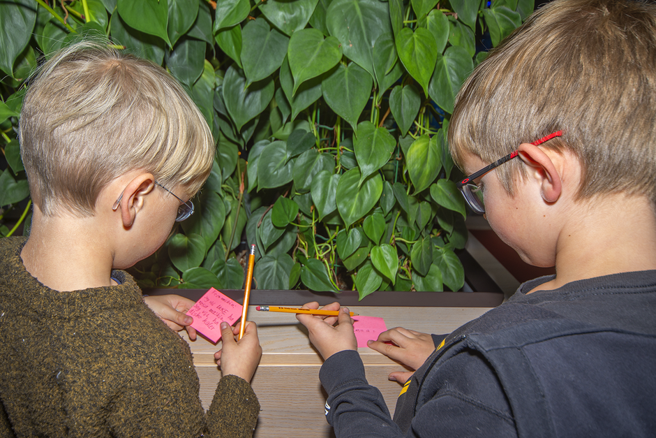 To barn som skriver forslag på post-it-lapper