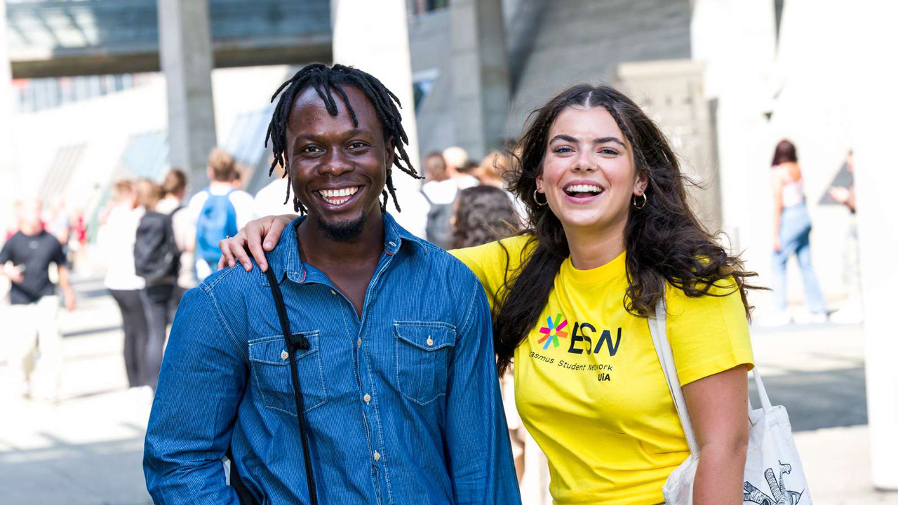 En kvinne i gul t-skjorte holder rundt en medstudent