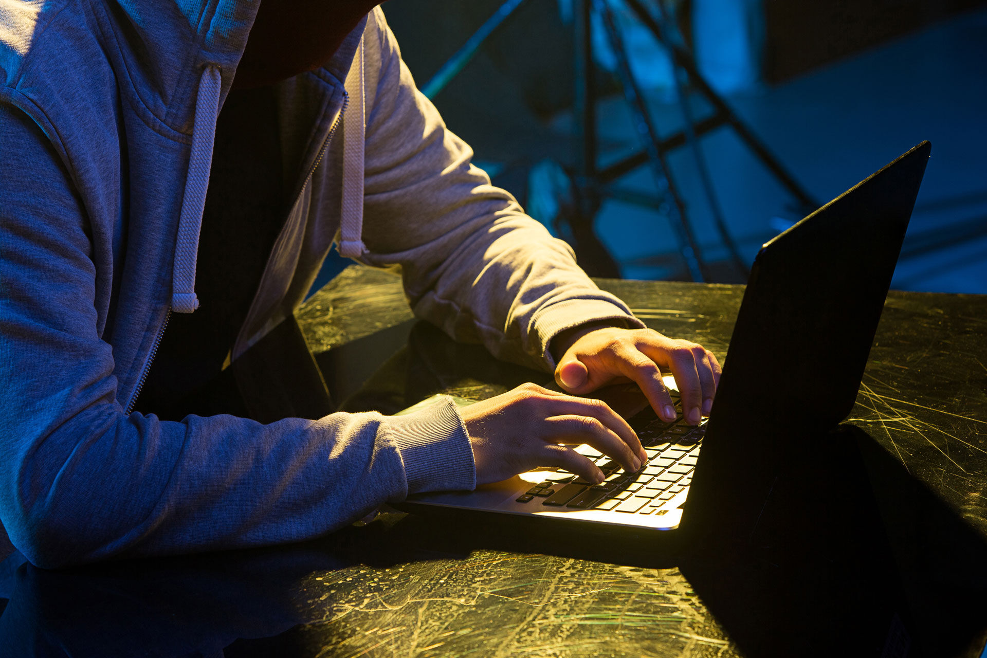 Foto av en person som sitter i mørket og skriver på en PC