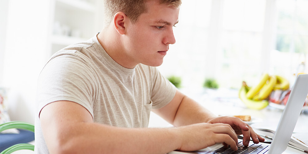 Mannlig student som jobber på laptop